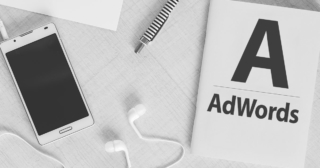 7 vychytávok AdWords, o ktorých ste možno ani nevedeli, pracovný stôl s telefónom a poznámkovým blokom