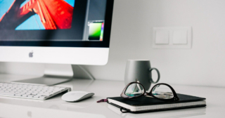 Nový člen v tíme ASData - grafik, webdeveloper, pracovný stôl s iMacom a zápisníkom